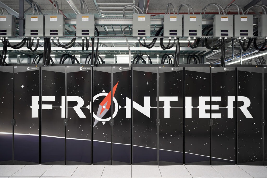A forward-facing view of the Frontier supercomputer. It's outer facing cabinets are black with the word Frontier. 