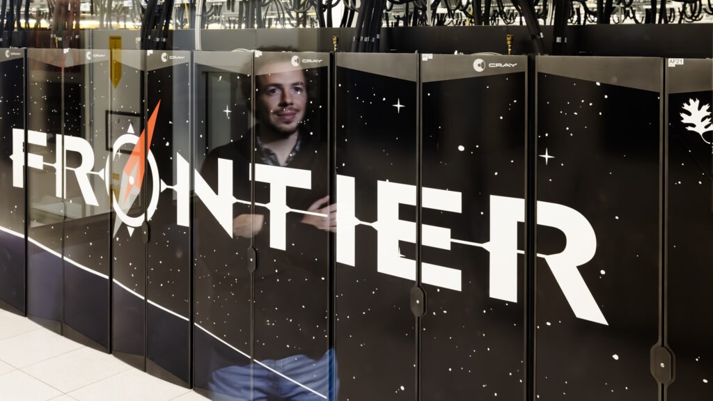 photo of front of Frontier supercomputer with researcher shown in the reflection.