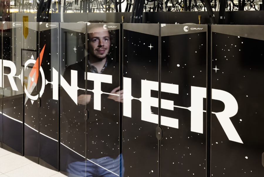 photo of front of Frontier supercomputer with researcher shown in the reflection.