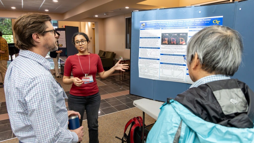 Rohini Vaideswaran explains her research poster on turbulence simulations generated with Frontier supercomputer data to attendees at the 2026 Oak Ridge Leadership Computing Facility User Summit.