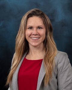 Posed portrait of person in grey jacket and red shirt