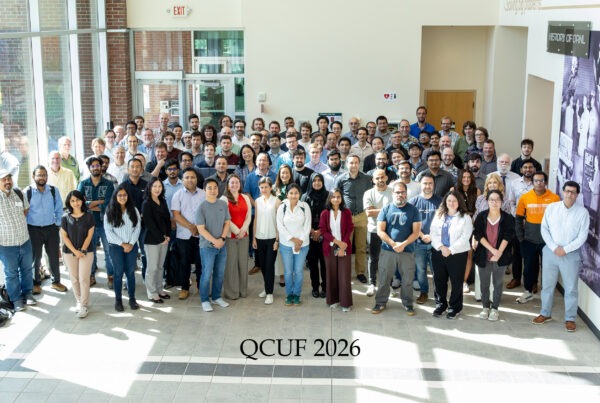 A large group of attendees at the 2026 Quantum Computing User Forum pose for a group photo in the Oak Ridge National Laboratory lobby beneath the U.S. Department of Energy and Oak Ridge National Laboratory wall signage.
