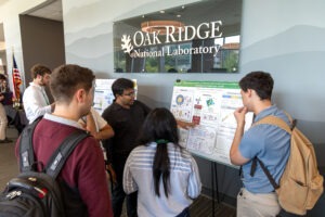 Manas Sajjan, Research Scientist in Quantum HPC Systems, discusses his research poster with conference attendees during the poster session at the 2026 Quantum Computing User Forum at Oak Ridge National Laboratory.